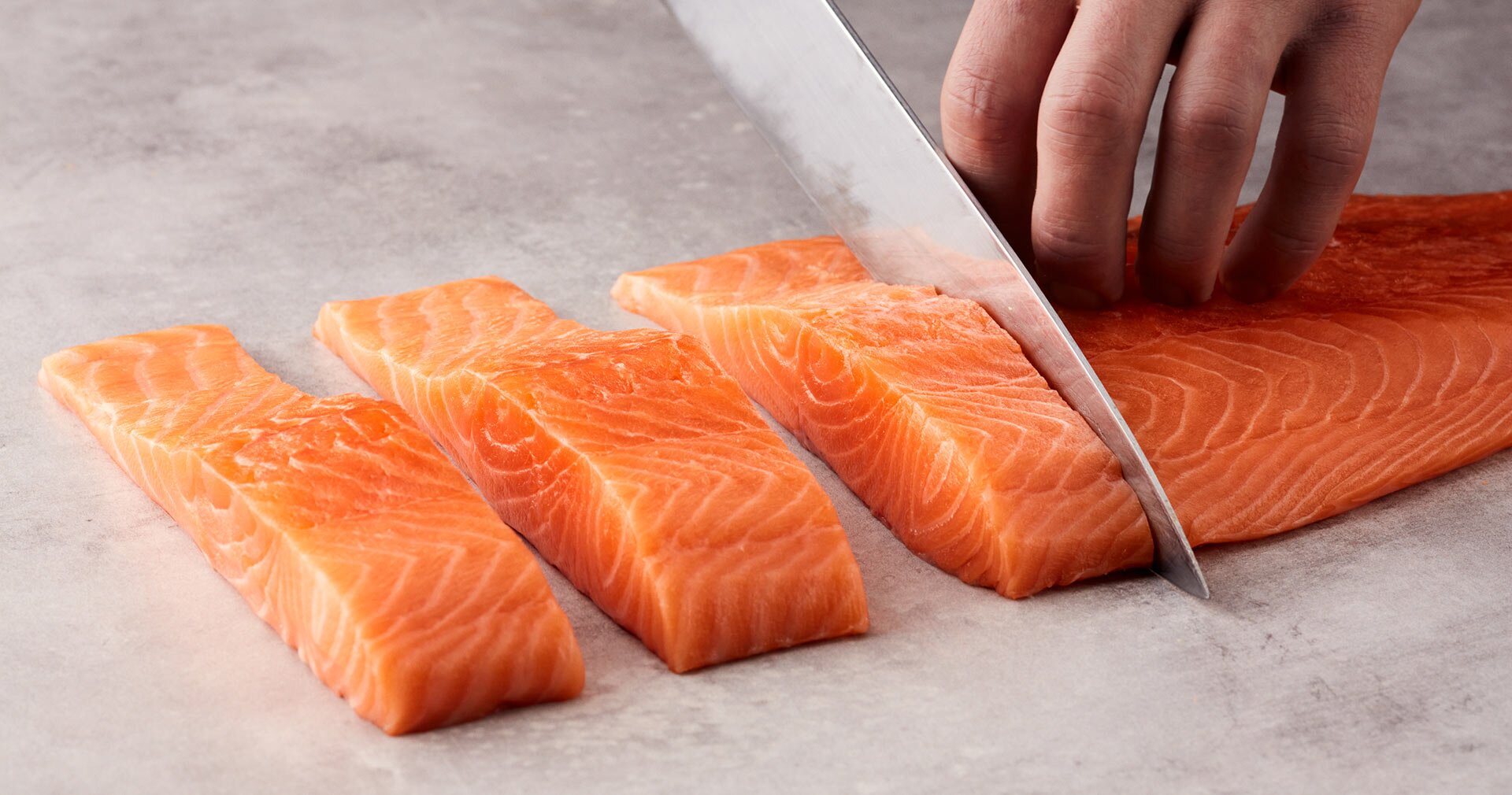 Skjærer laks i serveringsstykker