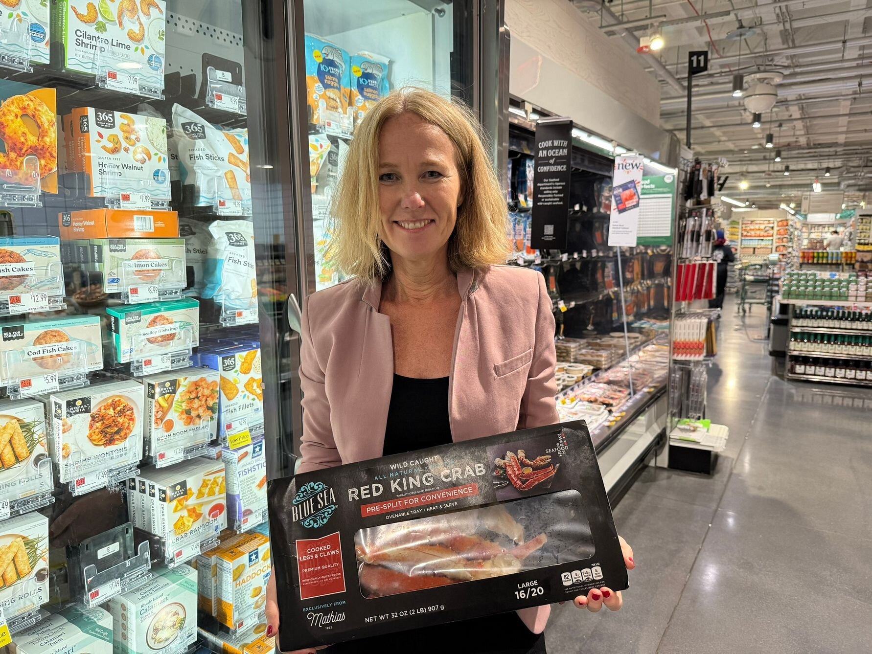 Sjømatutsending til USA, Karine Rød Haraldsson med kongekrabbe-produkt i butikk. 