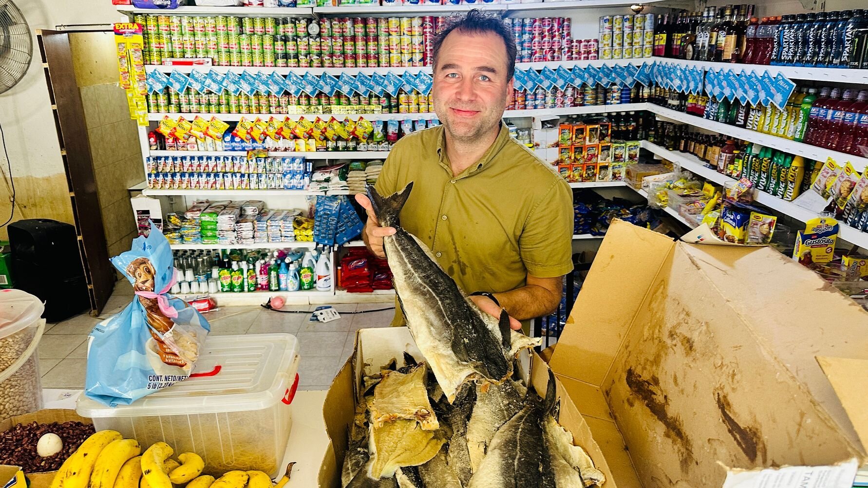 Mange dominkanere kjøper klippfisk over disk i nærbutikken sin. Fisken deles i biter etter ønsket mengde. Her er det Sjømatrådets Ørjan Kjærvik Olsen som får prøve seg som butikkansatt.