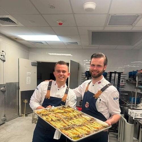 Landslagets egne kokker Aron Espeland (til venstre) og Eirik Tufte serverte de norske VM-heltene en eksklusiv sjømatmiddag lørdag kveld. Foto: Privat