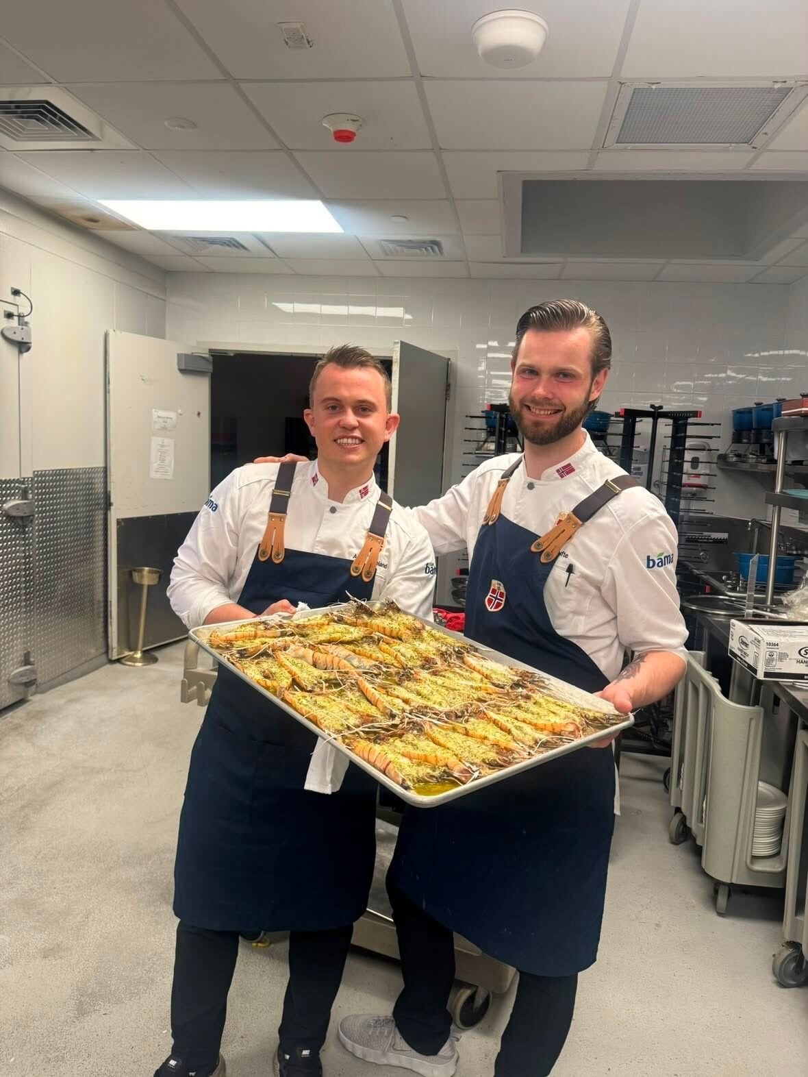 Landslagets egne kokker Aron Espeland (til venstre) og Eirik Tufte serverte de norske VM-heltene en eksklusiv sjømatmiddag lørdag kveld. Foto: Privat