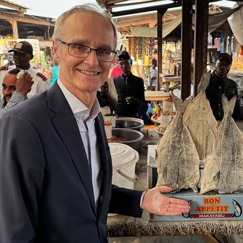Ambassadør Odd Mølster med norsk klippfisk av sei på utendørsmarked i Kinshasa, DRK Kongo